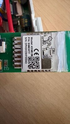 Close-up of an electronic module on a green PCB with a label, QR code, and CE mark