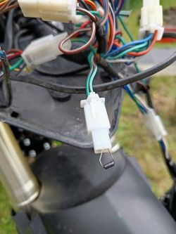 Zbliżenie na złącze elektryczne motocykla z opornikiem w plastikowej obudowie