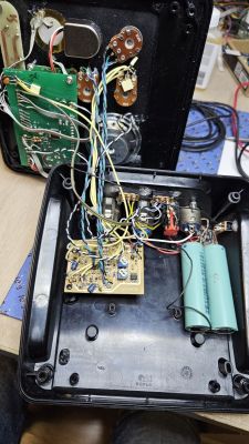 Wnętrze obudowy elektronicznego metronomu z widoczną płytką drukowaną, przewodami i elementami audio.
