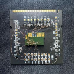 Circuit board with a microchip and soldered wires on a black background.