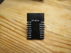 Cozylife DT-BL12 Module Cozylife DT-BL12 module with visible pins on a wooden surface.