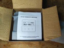 “WT200 Thermostat User Guide” booklet inside an open cardboard box