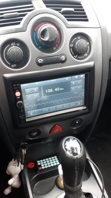 Car dashboard with a 7010b radio displaying 106.40 MHz on the screen.