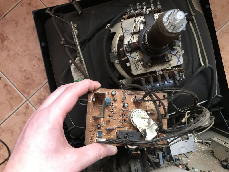 Zdemontowana płytka kineskopu trzymana przed wnętrzem telewizora Sony Trinitron