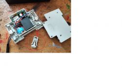 Disassembled electrical box with a red-circled plastic component.