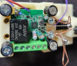 Close-up of Smart Switch with Programming Wires Attached Close-up of an assembled electronic circuit with a smart relay and wires connected to programming pins.