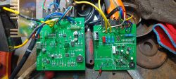 Dwie płytki elektroniczne na stole warsztatowym.