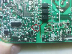 Wnętrze płytki drukowanej z zasilacza Microsoft CPA09-011A z zaznaczonym na czerwono elementem.