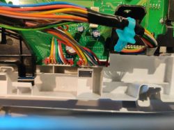Elementy wewnętrzne urządzenia elektronicznego z widocznymi przewodami i płytką drukowaną.