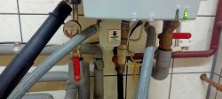 Zamknięta wajcha przy instalacji grzewczej z manometrem i oznaczeniem Pull to check.