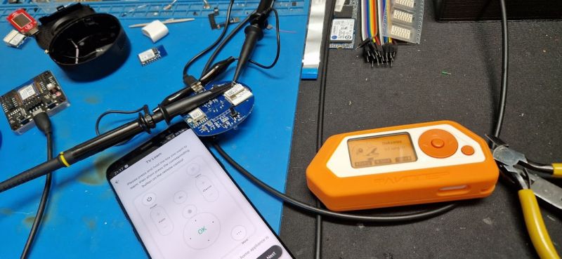 Experimenting with IR Signal Capture using Flipper Zero Flipper Zero on a desk with electronic devices and a smartphone.