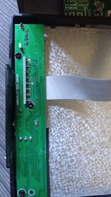 Nahaufnahme einer grünen Leiterplatte mit einem Flachbandkabel in einem elektronischen Gerät.