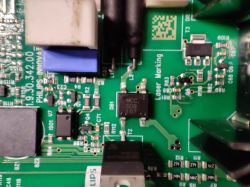 Zbliżenie na zieloną płytkę drukowaną z komponentami elektronicznymi i oznaczeniami