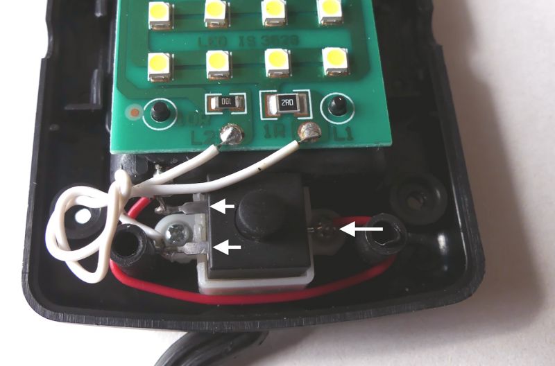 Wnętrze lampki LED z widoczną płytką drukowaną i połączeniami przewodów.