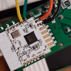 Close-up of a circuit board with a mounted microprocessor and colorful wires attached to connectors.