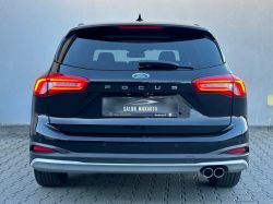 Black Ford Focus, rear view, parked on a cobblestone pavement.