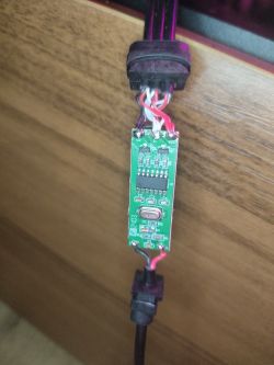 Płytka obwodu elektronicznego z podłączonymi przewodami, umieszczona na drewnianej powierzchni.