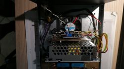 Wnętrze obudowy elektronicznej z zasilaczem i wentylatorem.