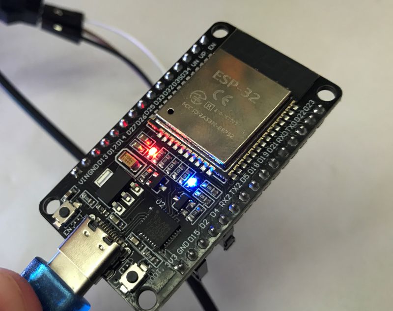 ESP32 Module with Power Connection ESP32 module with USB cable connected and lit LED lights.