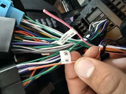 Zbliżenie na wiązkę przewodów radia samochodowego z oznaczeniami AMP i IR OUT