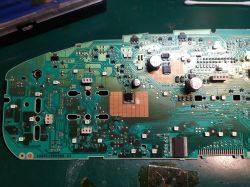 Płytka drukowana licznika samochodowego na stole warsztatowym.