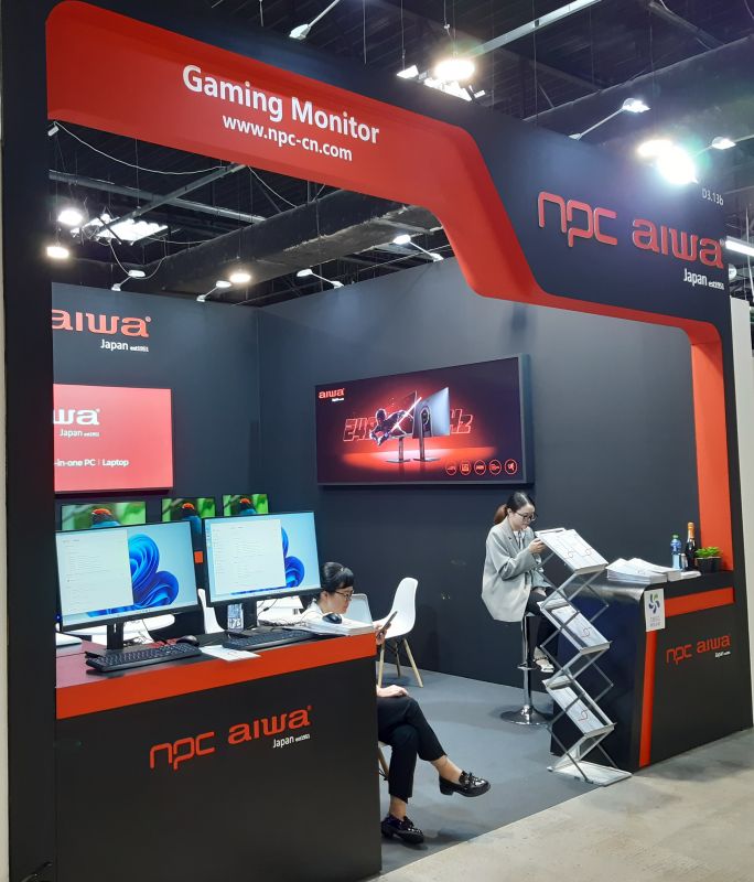 Stoisko firmy Aiwa na targach elektroniki z gamingowym monitorem wystawowym.
