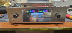 Metal audio front panel with screen and two knobs on a workshop bench