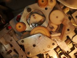 Zbliżenie na mechanizm z kołami zębatymi i metalową blaszką