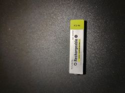Akumulator Sony NC-6WM leżący na czarnej powierzchni.