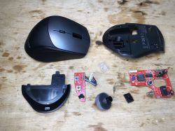 Disassembled BW-MO2 Mouse Disassembled parts of the BW-MO2 mouse on a wooden surface.