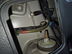 Widok wnętrza bagażnika Suzuki SX4 z przewodami i podłączeniem masy