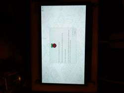 Ekran LCD Waveshare z logo Raspberry Pi i tekstem powitalnym, podłączony do Raspberry Pi 4B.