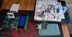 Zestaw płytek PCB i breadboard z elementami elektronicznymi na biurku.