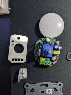 Disassembly of LSC Connect Smart Dimmer Disassembled LSC Connect smart wall dimmer with visible electronics on a dark background.