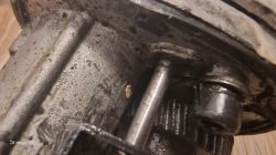 Zbliżenie na mechanizm wewnętrzny wiertarki lub młotowiertarki z widocznymi wałkami i zębatkami.