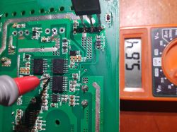 Digital multimeter showing 5.64 V voltage reading on a circuit board, using a probe.