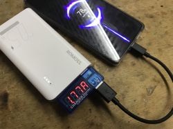 Powerbank Romoss ładuje smartfon, pomiar natężenia prądu wskazuje 1.77A, ekran telefonu pokazuje ładowanie i poziom baterii 78%.