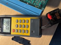Multimetr DE-5000 mierzący element indukcyjny podłączony do transformatora.