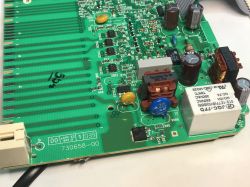 Fragment elektronicznej płytki PCB z elementami zasilania, przekaźnikiem, cewkami i kondensatorami, widoczne ścieżki i oznaczenia.