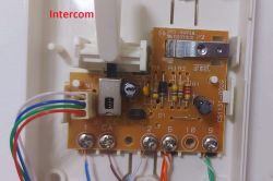 Intercom Circuit Board with Wiring The inside of an intercom panel with a circuit board, wires, and electronic components visible.
