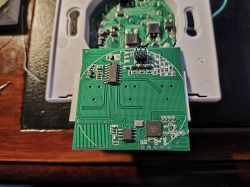 Image of a printed circuit board with electronic components, resting on the casing of another device.