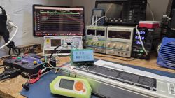 Ekran LCD z odczytem 41.07V podłączony do zestawu laboratoryjnego na stole