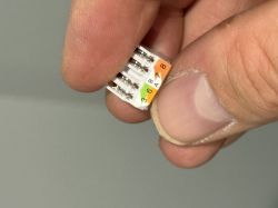 Zbliżenie na wtyczkę sieciową RJ45 w ręku.