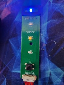 Close-up of an electronic module with three LEDs and a button.