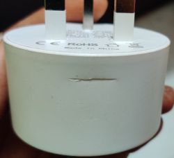 Close-up of an electrical plug adapter with visible scratches.