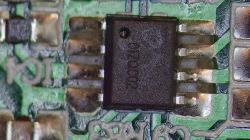 Układ scalony SMD zamontowany na zielonej płytce PCB w dużym zbliżeniu, oznaczenie 01G002.