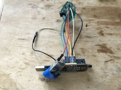 SPI programmer connected to a circuit board with colored wires on a wooden workspace