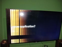 Telewizor z pionowymi jasnymi pasami i tekstem Leave application? na ekranie.