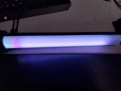 LED lamp emitting blue-violet light on a desk.