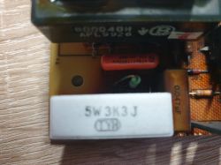 Widok elementów na płytce zasilacza ARTSYN NFS50-7608, w tym rezystora i kondensatorów.